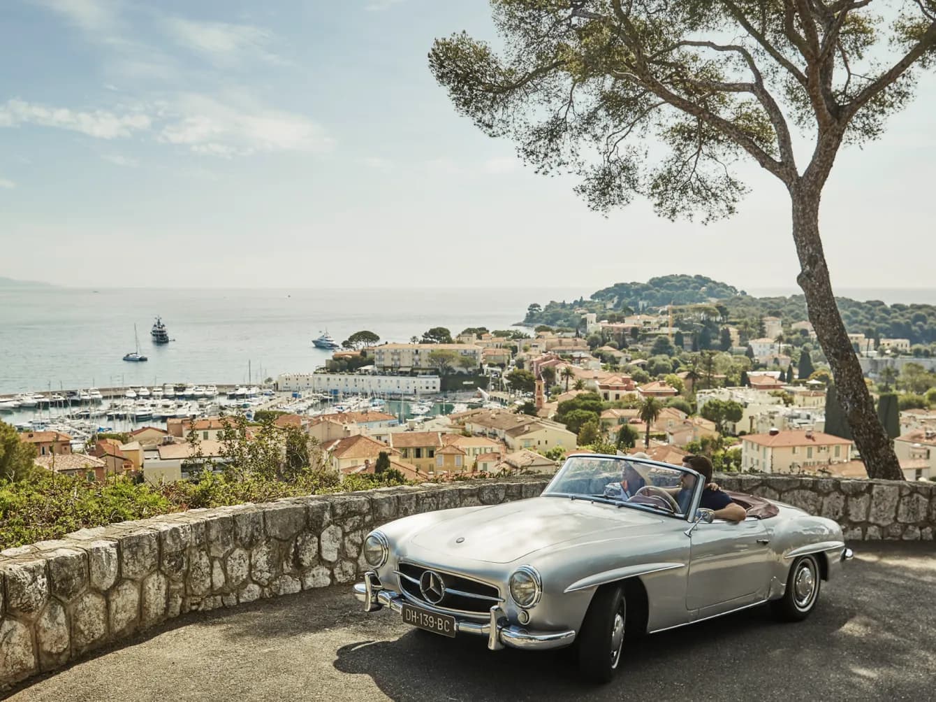 Couple in a convertible car overlooking the ocean